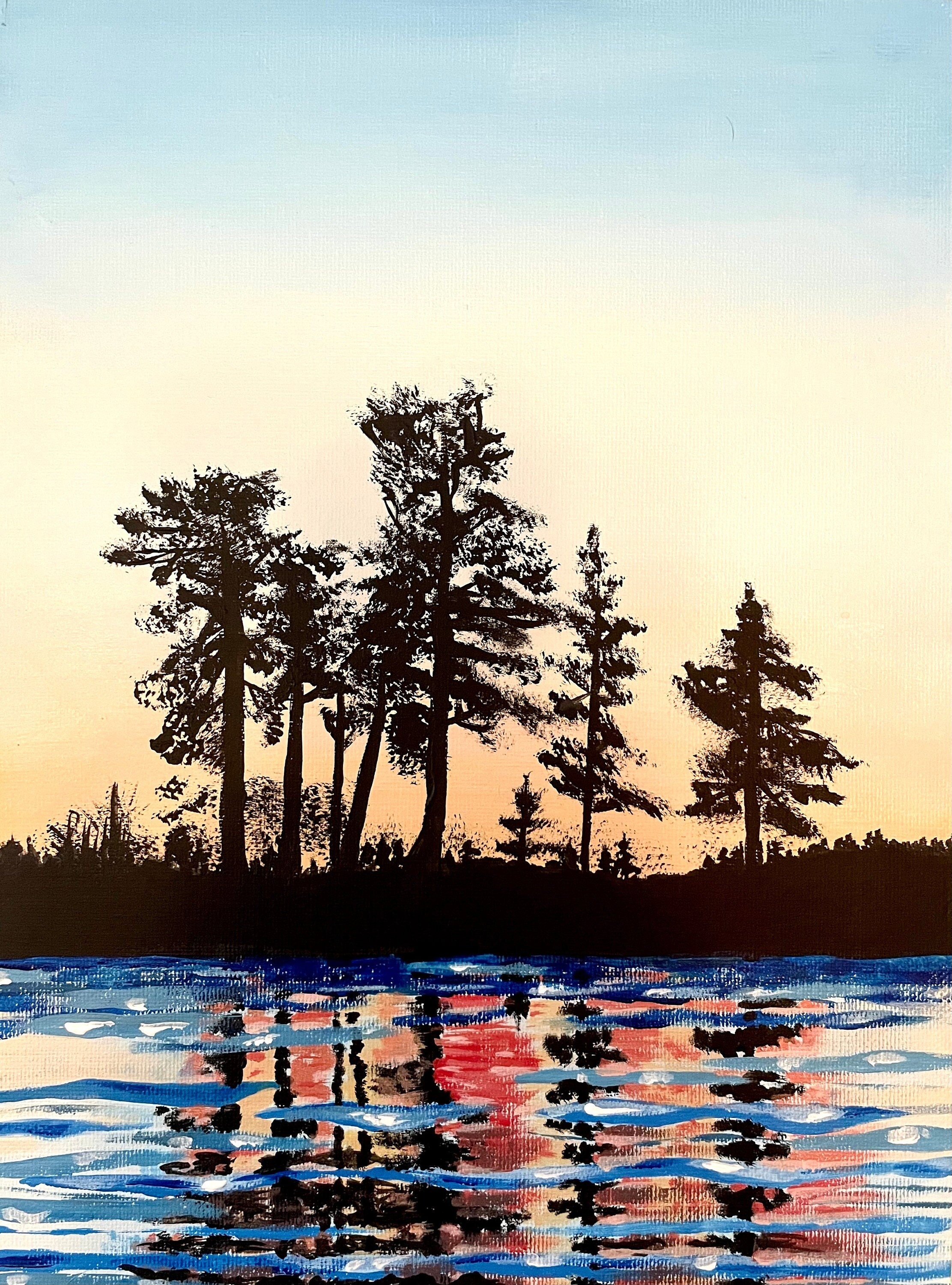 Dark trees and a blue and yellow evening sky reflect on the lake below.