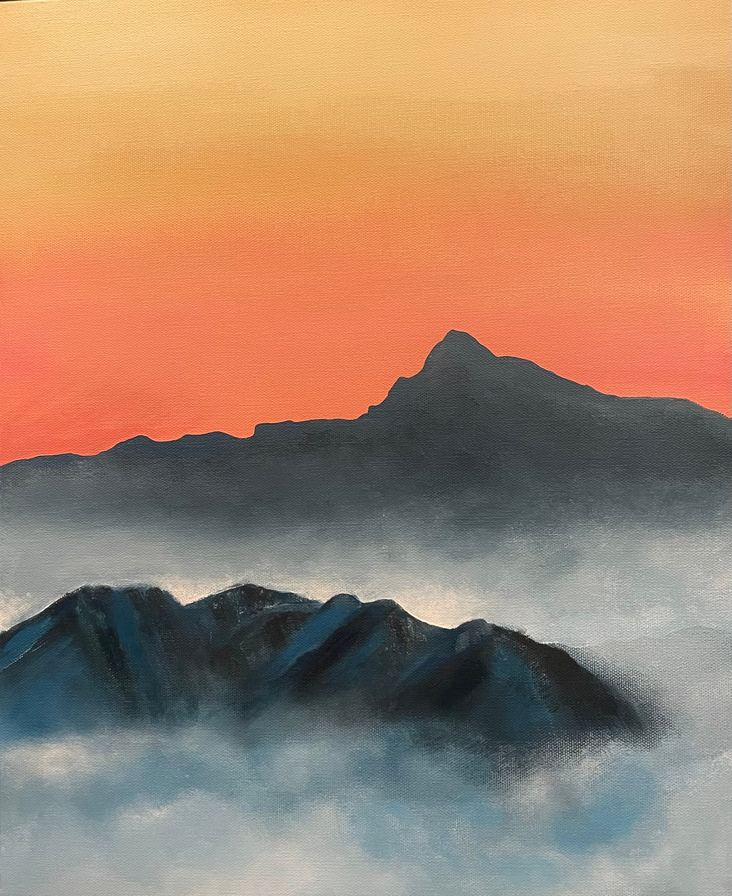 A bright orange and pink sky hangs above navy mountains and ribbons of mist.