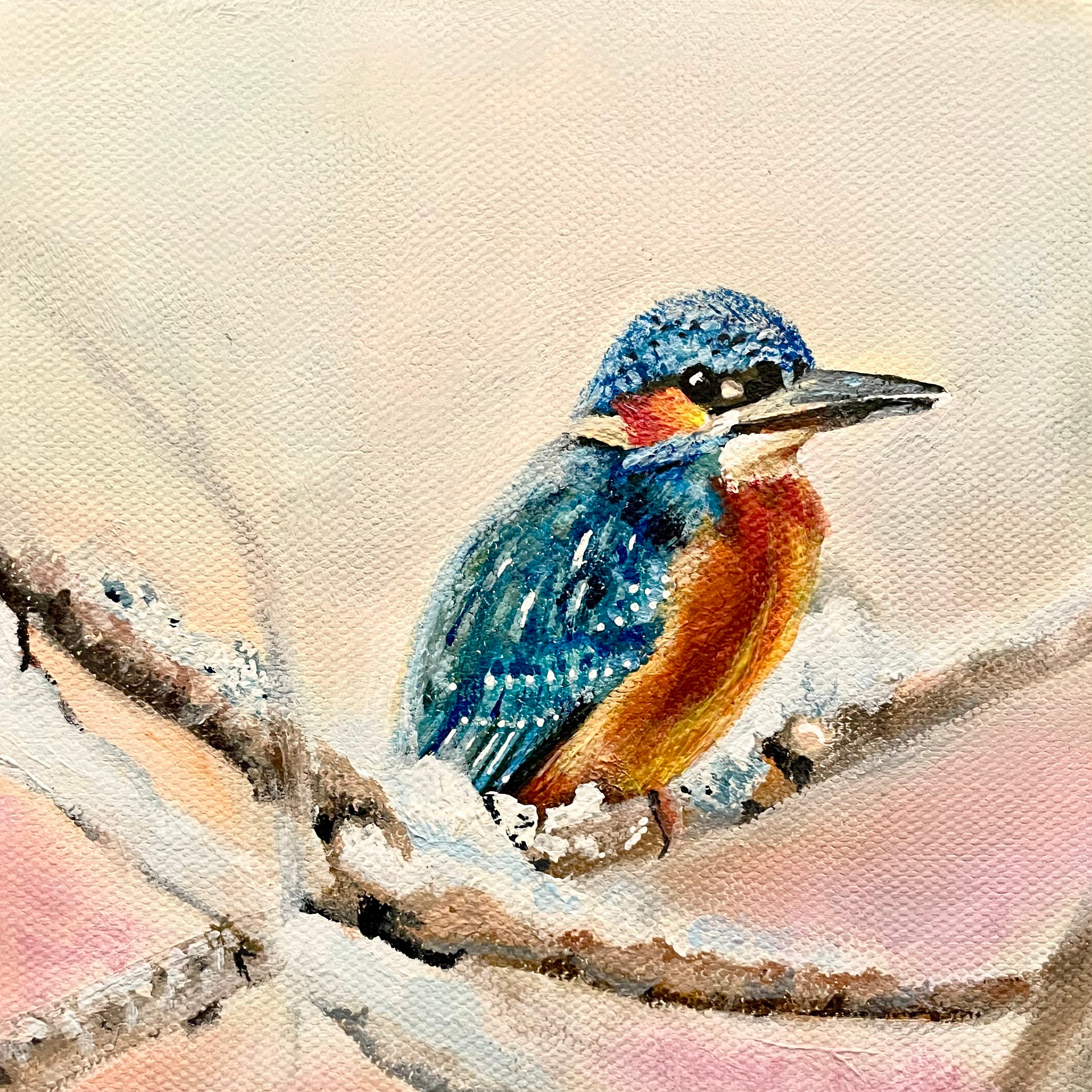 A bluebird rests on a snowy branch, its warm orange breast glowing against the soft winter sky.